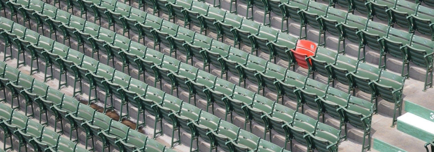 one red chair in a sea of green chairs